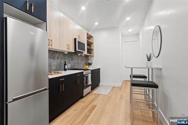 50 Grace St Unit 2R, Jersey City, NJ 07307 - kitchen featuring appliances with stainless steel finishes, decorative backsplash, light countertops, light wood-style flooring, and open shelves