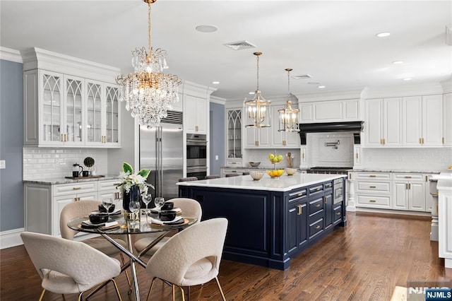 504 Kendrick St, Paramus, NJ 07652 - kitchen featuring blue cabinets, premium appliances, a chandelier, white cabinets, and ornamental molding
