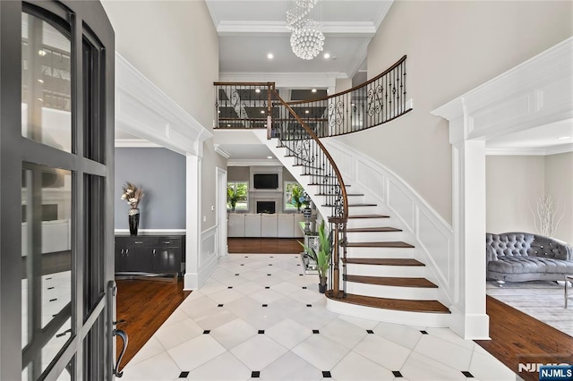 504 Kendrick St, Paramus, NJ 07652 - foyer entrance with a high ceiling, stairs, crown molding, a decorative wall, and a chandelier