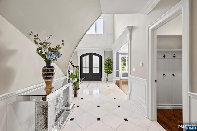 504 Kendrick St, Paramus, NJ 07652 - tiled foyer featuring a wainscoted wall, french doors, vaulted ceiling, and a decorative wall