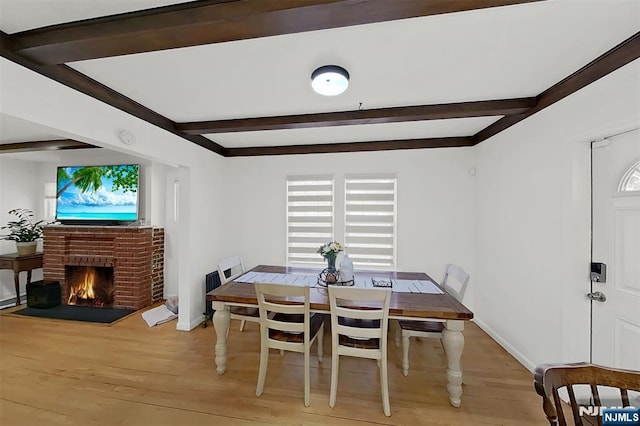 107 Elm St, West Orange, NJ 07052 - dining room with light wood-style flooring, beam ceiling, a brick fireplace, and baseboards