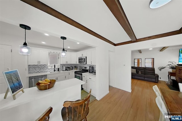 107 Elm St, West Orange, NJ 07052 - kitchen with appliances with stainless steel finishes, a sink, tasteful backsplash, white cabinetry, and light wood-style flooring