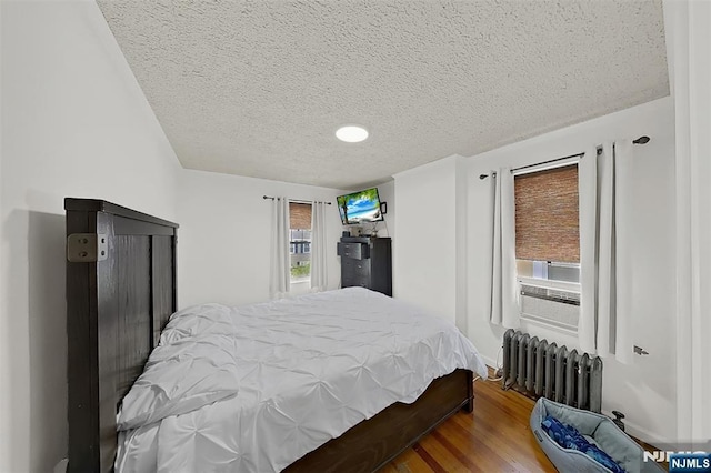 107 Elm St, West Orange, NJ 07052 - bedroom featuring radiator heating unit, a textured ceiling, and wood finished floors