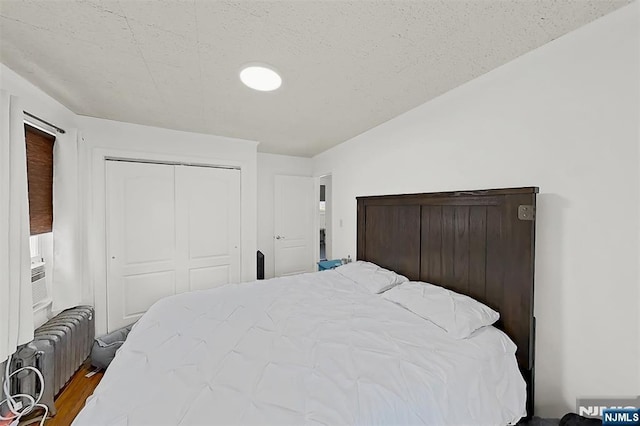 107 Elm St, West Orange, NJ 07052 - bedroom with radiator, a closet, and wood finished floors