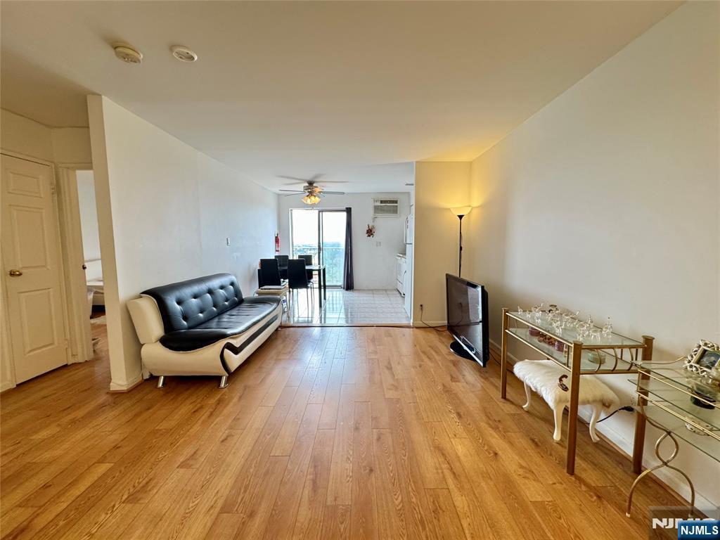 201 12th St Unit 20, Palisades Park, NJ 07650 - living area with light wood-style flooring, a wall mounted air conditioner, and a ceiling fan