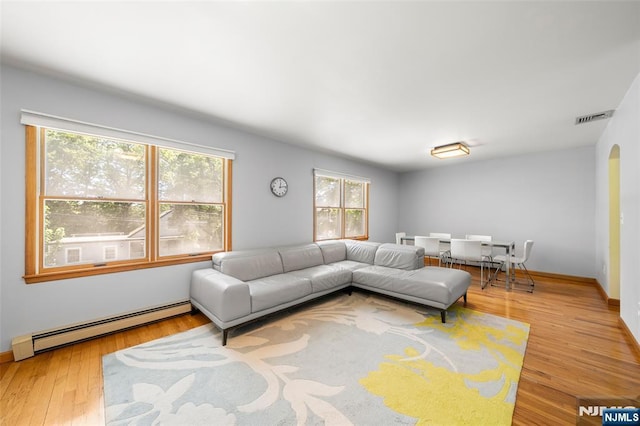 67 Short Pl, Cresskill, NJ 07626 - living area with a baseboard heating unit, plenty of natural light, wood finished floors, and baseboards