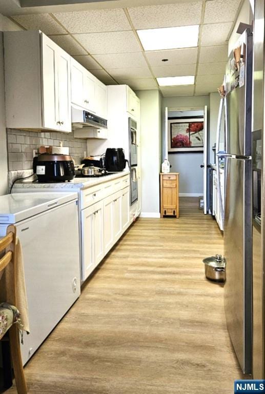 800 Palisade Ave Unit 1008, Fort Lee, NJ 07024 - kitchen featuring under cabinet range hood, appliances with stainless steel finishes, white cabinetry, a paneled ceiling, and light countertops