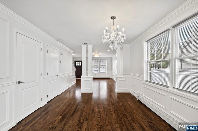 15 Kossuth St, Wallington, NJ 07057 - unfurnished dining area featuring ornate columns, a decorative wall, dark wood finished floors, a chandelier, and crown molding