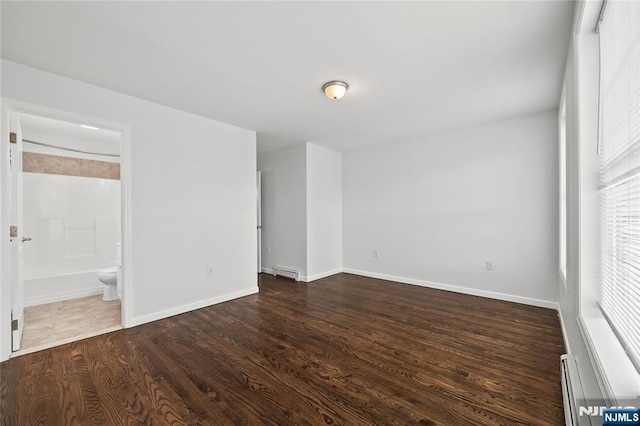 15 Kossuth St, Wallington, NJ 07057 - empty room with wood finished floors, baseboards, and a baseboard radiator