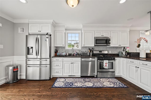15 Kossuth St, Wallington, NJ 07057 - kitchen with stainless steel appliances, a sink, ornamental molding, white cabinetry, and dark wood-style flooring