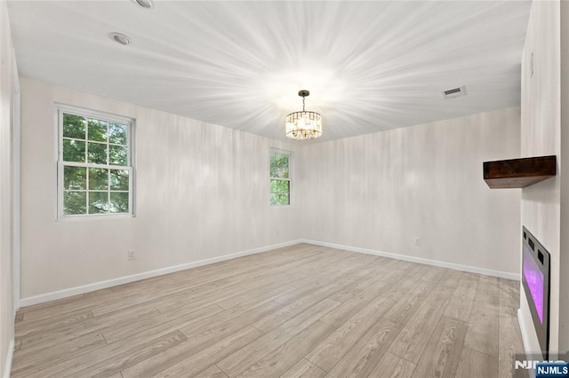 428 Elm Ave, River Edge, NJ 07661 - unfurnished living room with light wood finished floors, plenty of natural light, a chandelier, and baseboards