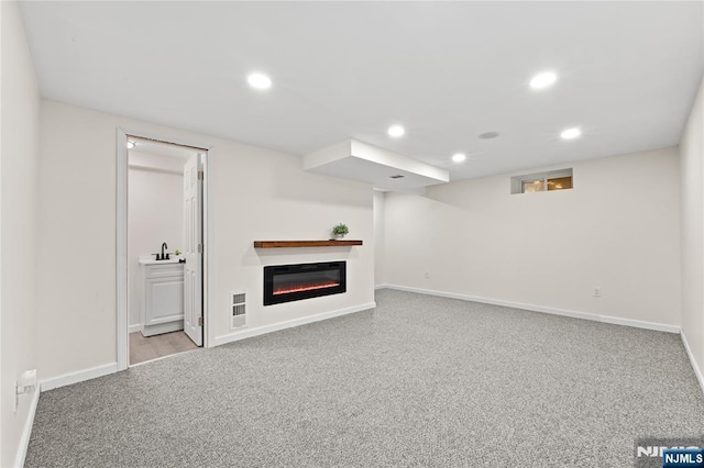 428 Elm Ave, River Edge, NJ 07661 - finished below grade area with baseboards, recessed lighting, a glass covered fireplace, a sink, and carpet