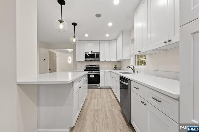 428 Elm Ave, River Edge, NJ 07661 - kitchen with stainless steel appliances, a sink, white cabinets, hanging light fixtures, and recessed lighting