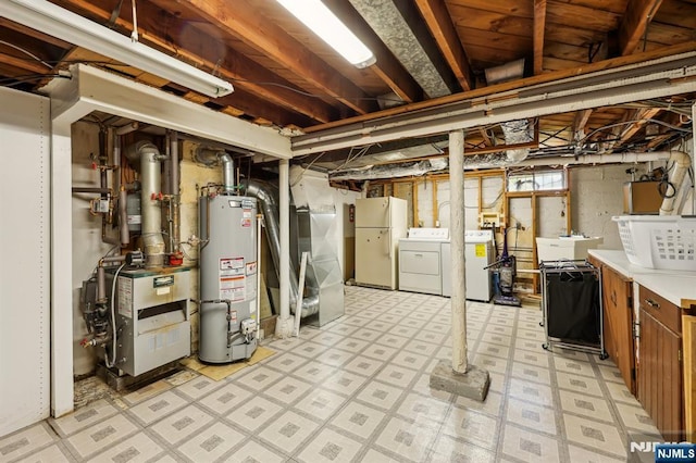 650 5th Ave, River Edge, NJ 07661 - below grade area featuring water heater, washing machine and clothes dryer, freestanding refrigerator, light floors, and a heating unit