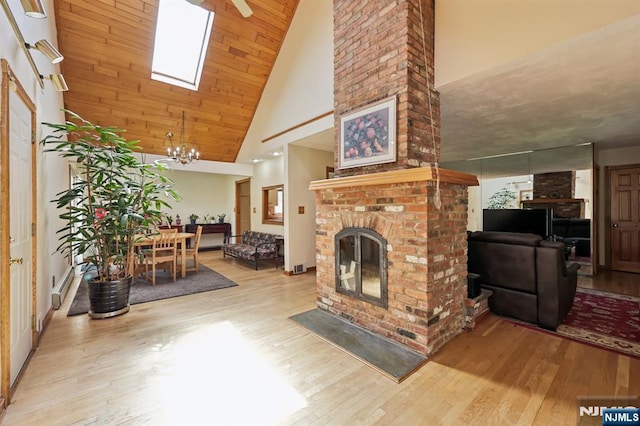 650 5th Ave, River Edge, NJ 07661 - living room with high vaulted ceiling, wood finished floors, a fireplace, and a chandelier