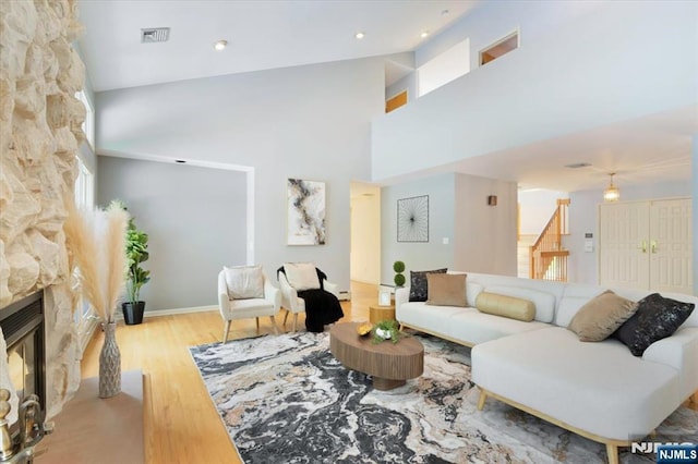 33 Willow Brk, North Caldwell, NJ 07006 - living area with wood finished floors, a fireplace, a towering ceiling, stairs, and baseboards