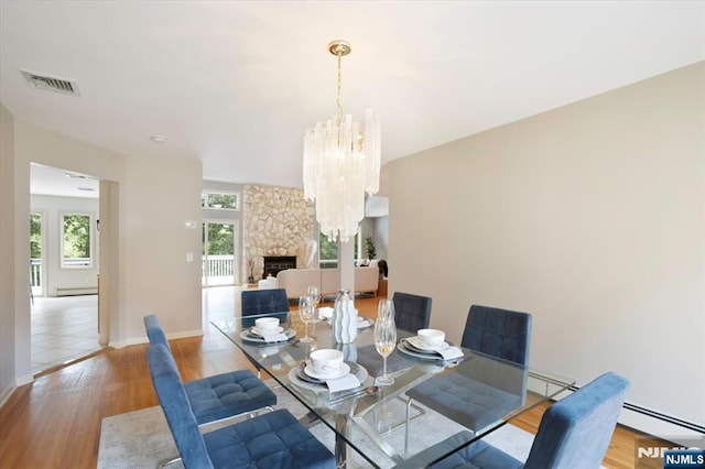 33 Willow Brk, North Caldwell, NJ 07006 - dining area with healthy amount of natural light, wood finished floors, a chandelier, and a fireplace