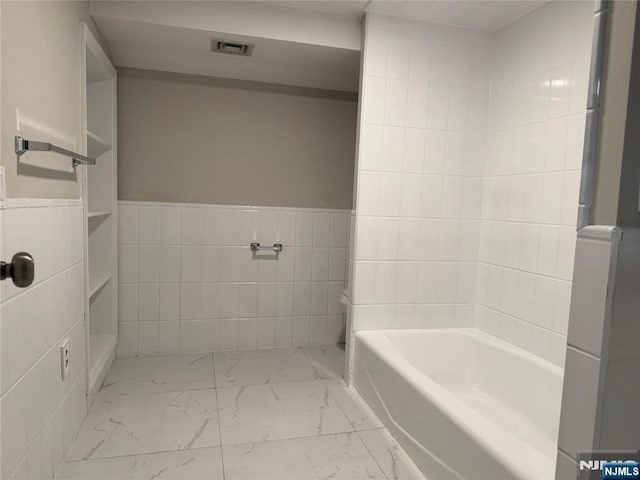 41 Woods Ave, Bergenfield, NJ 07621 - full bathroom featuring marble look tiles, a tub, and tile walls