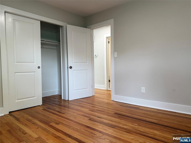41 Woods Ave, Bergenfield, NJ 07621 - unfurnished bedroom with wood finished floors, baseboards, and a closet