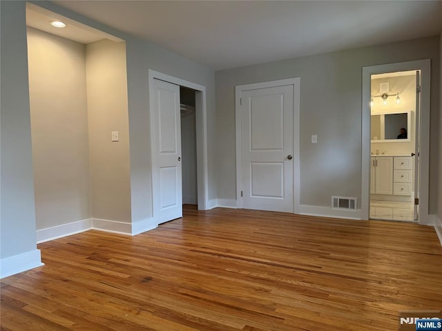 41 Woods Ave, Bergenfield, NJ 07621 - unfurnished bedroom featuring wood finished floors, baseboards, a closet, ensuite bathroom, and a sink