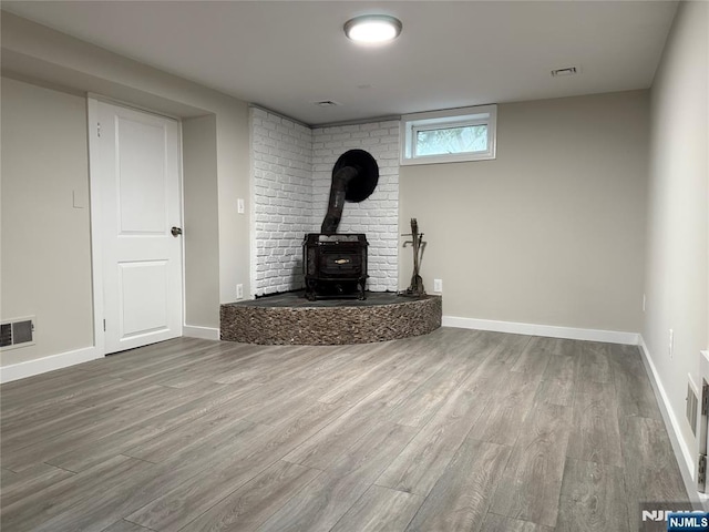 41 Woods Ave, Bergenfield, NJ 07621 - unfurnished living room with a wood stove, wood finished floors, and baseboards