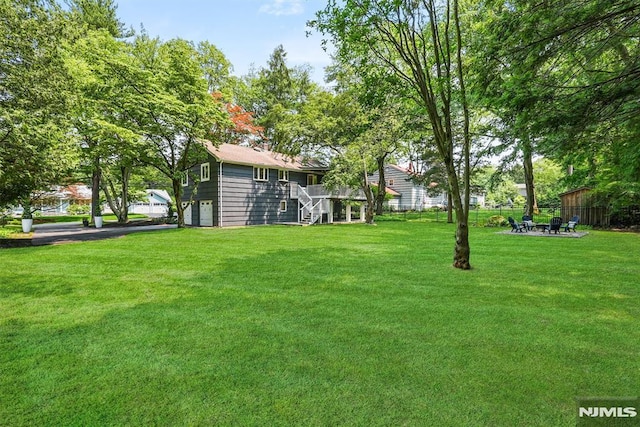 104 Myrtle Ave, Ramsey, NJ 07446 - view of grassy yard featuring stairway, an attached garage, and a deck