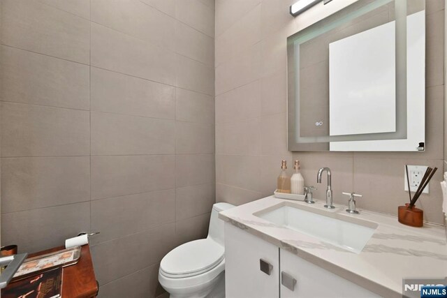 716 Undercliff Ave, Edgewater, NJ 07020 - bathroom with tile walls, vanity, and toilet