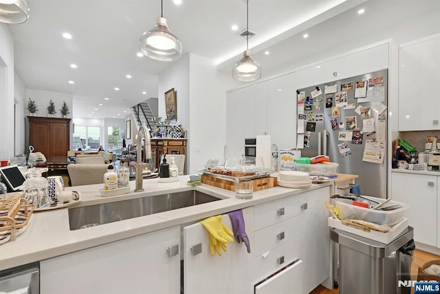 716 Undercliff Ave, Edgewater, NJ 07020 - kitchen with a sink, stainless steel fridge, white cabinets, light countertops, and recessed lighting