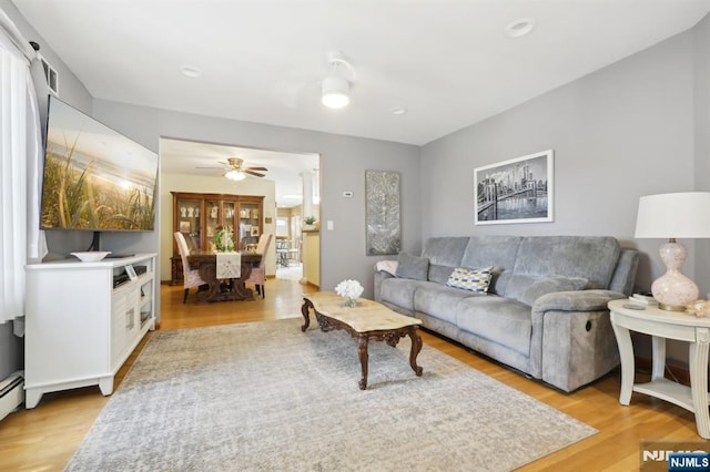 300 Wilson Ave, Lyndhurst, NJ 07071 - living room featuring light wood-style flooring, ceiling fan, and baseboard heating
