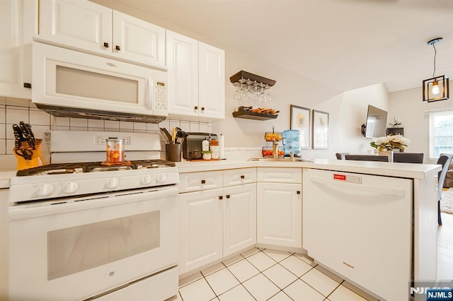 101 Royal Ave Unit 40, Hawthorne, NJ 07506 - kitchen featuring white appliances, a peninsula, a sink, backsplash, and white cabinetry