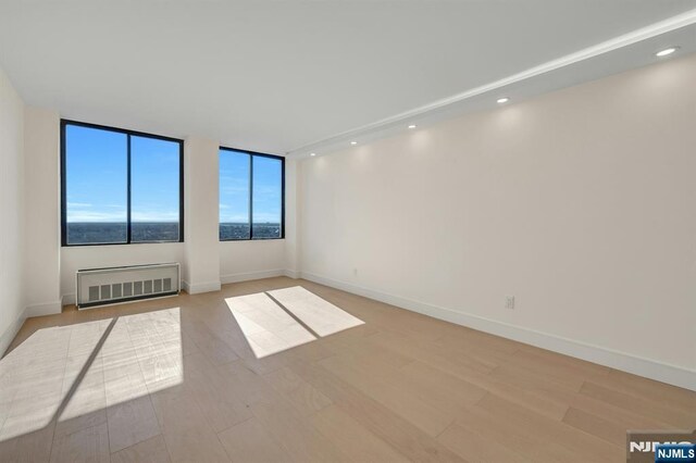 200 Winston Unit 2912, Cliffside Park, NJ 07010 - unfurnished room featuring radiator, light wood-style floors, baseboards, and recessed lighting