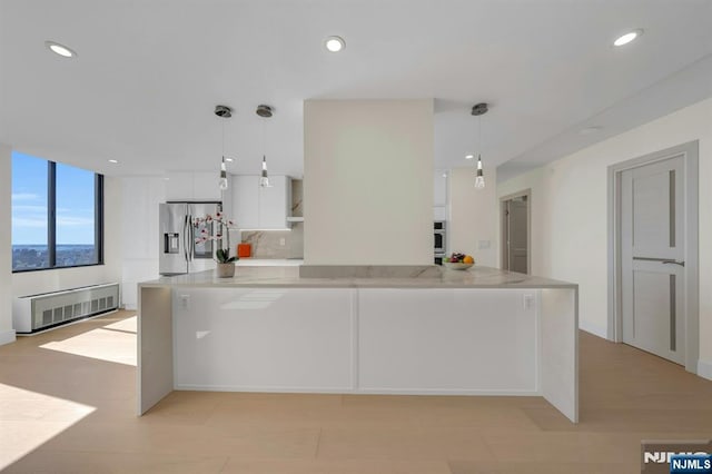 200 Winston Unit 2912, Cliffside Park, NJ 07010 - kitchen featuring stainless steel fridge with ice dispenser, white cabinetry, recessed lighting, hanging light fixtures, and radiator heating unit