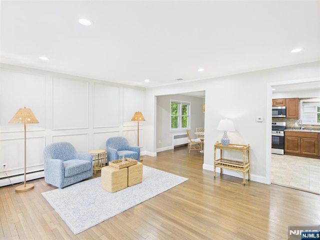 440 Albin Ct, Ridgewood, NJ 07450 - living area with radiator heating unit, a baseboard radiator, a decorative wall, light wood finished floors, and recessed lighting