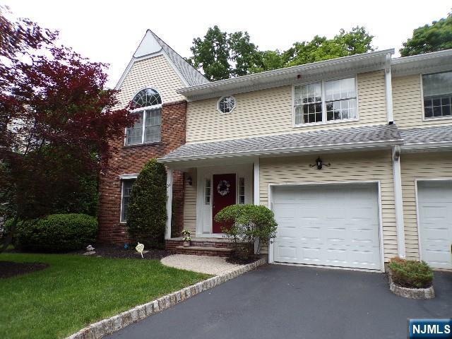 20 Carriage Ln, Ridgewood, NJ 07450 - townhome / multi-family property featuring an attached garage, driveway, and a front lawn