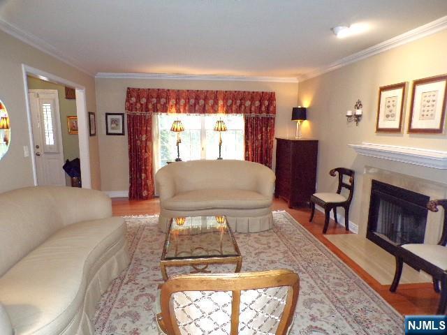 20 Carriage Ln, Ridgewood, NJ 07450 - living room with ornamental molding, wood finished floors, and a fireplace with flush hearth