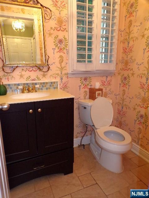 20 Carriage Ln, Ridgewood, NJ 07450 - bathroom featuring tile patterned floors, vanity, toilet, baseboards, and wallpapered walls