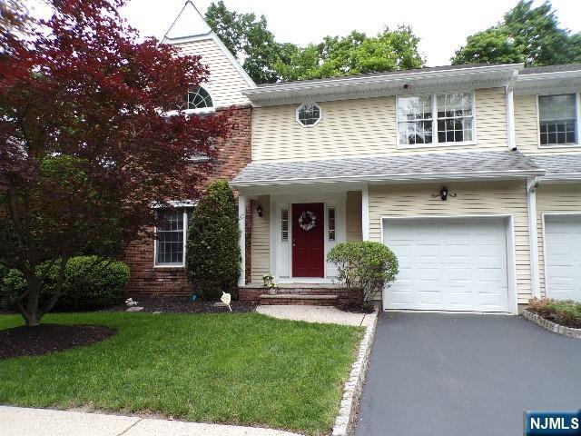 20 Carriage Ln, Ridgewood, NJ 07450 - view of front of house featuring an attached garage, driveway, a front yard, and a shingled roof