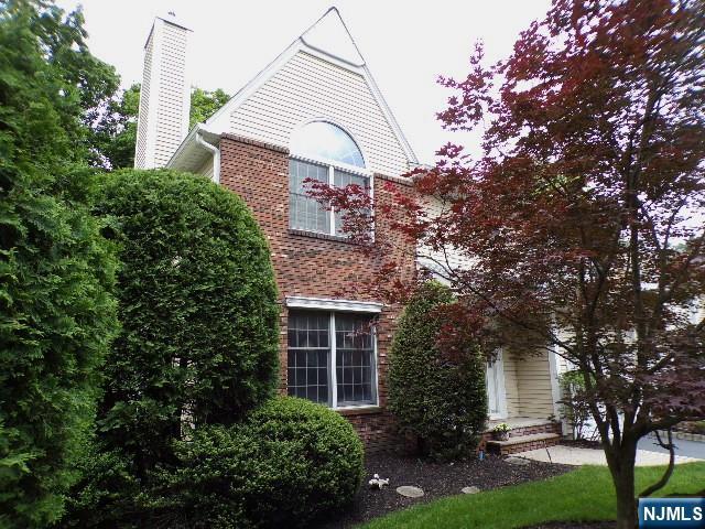 20 Carriage Ln, Ridgewood, NJ 07450 - view of property exterior with a chimney and brick siding