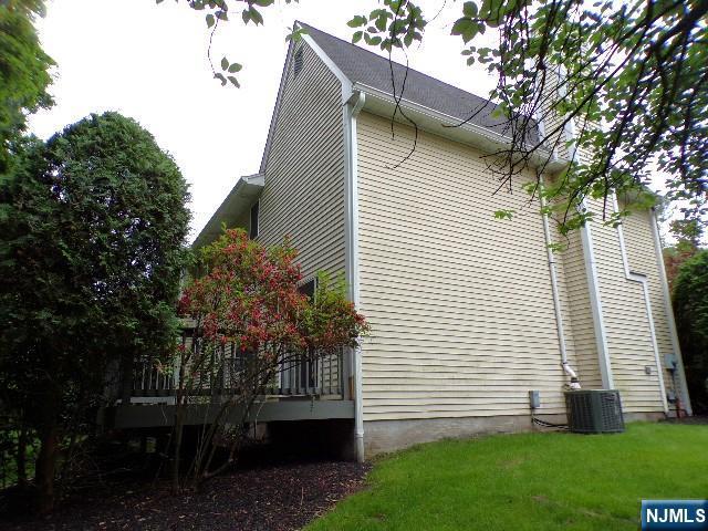 20 Carriage Ln, Ridgewood, NJ 07450 - view of side of home featuring central AC unit, a yard, and a deck