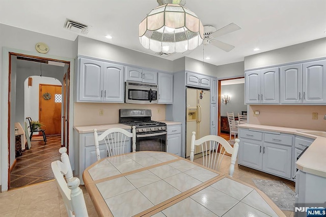 42 Cecilia Dr, Wayne, NJ 07470 - kitchen with appliances with stainless steel finishes, arched walkways, a ceiling fan, light tile patterned floors, and light countertops
