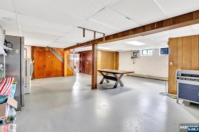 42 Cecilia Dr, Wayne, NJ 07470 - basement featuring a drop ceiling, freestanding refrigerator, stairs, wooden walls, and heating unit