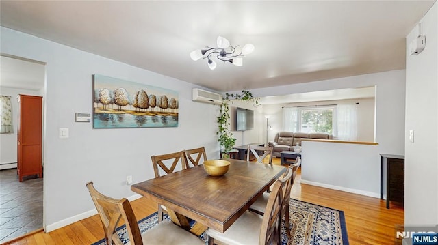 336 Ridgewood Blvd, Twp Of Washington, NJ 07676 - dining area with a chandelier, light wood finished floors, a wall mounted AC, baseboards, and baseboard heating