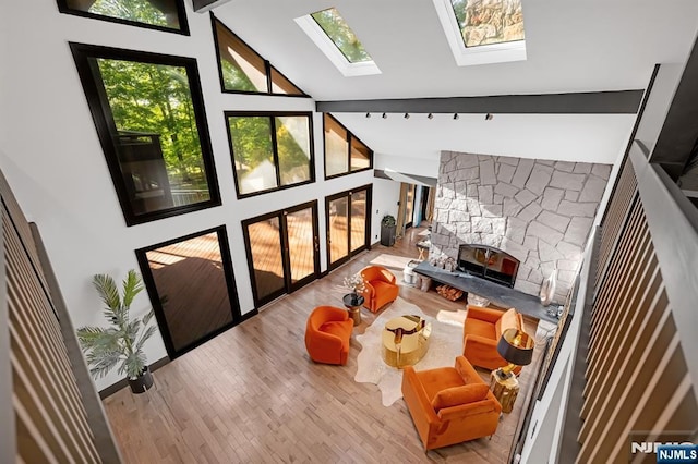 18 Lomas Ln, Montvale, NJ 07645 - living room featuring vaulted ceiling, a fireplace, a skylight, and wood finished floors
