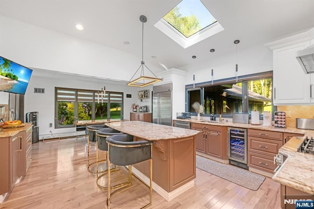 18 Lomas Ln, Montvale, NJ 07645 - kitchen featuring wine cooler, appliances with stainless steel finishes, a sink, a center island, and light stone counters