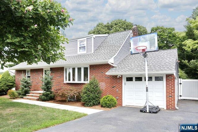 2 Hartland Ave, Emerson, NJ 07630 - view of front of house featuring brick siding, roof with shingles, driveway, an attached garage, and a chimney