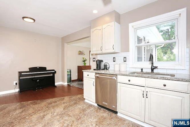 2 Hartland Ave, Emerson, NJ 07630 - kitchen featuring stainless steel dishwasher, a sink, light stone counters, white cabinets, and baseboards