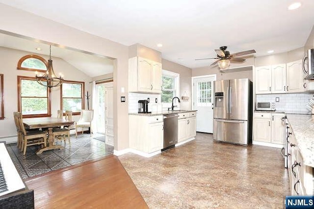 2 Hartland Ave, Emerson, NJ 07630 - kitchen with stainless steel appliances, a sink, a chandelier, white cabinetry, and backsplash