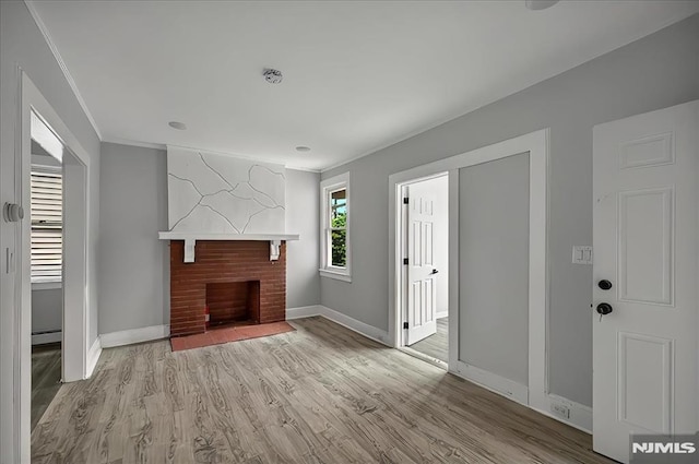 27 Berkeley Pl, Bloomfield, NJ 07003 - unfurnished living room with baseboards, wood finished floors, ornamental molding, a brick fireplace, and baseboard heating