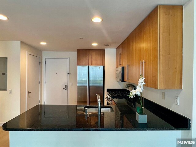 800 12th St Unit 207, Palisades Park, NJ 07650 - kitchen featuring stainless steel appliances, brown cabinets, a peninsula, a sink, and recessed lighting