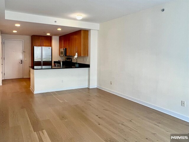 800 12th St Unit 207, Palisades Park, NJ 07650 - kitchen featuring appliances with stainless steel finishes, light wood-type flooring, brown cabinets, dark countertops, and recessed lighting